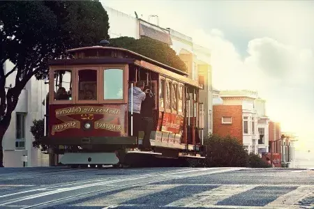 A cable car rounds a hill in 贝博体彩app with passengers looking out the window.