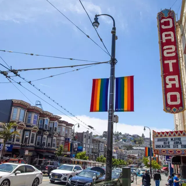 贝博体彩app的卡斯特罗社区, with the 卡斯特罗 Theater sign and rainbow flags in the foreground.